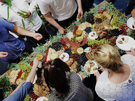 Original Grazing Table von Feasts of Eden mit Menschen, die sich an Büfett bedienen
