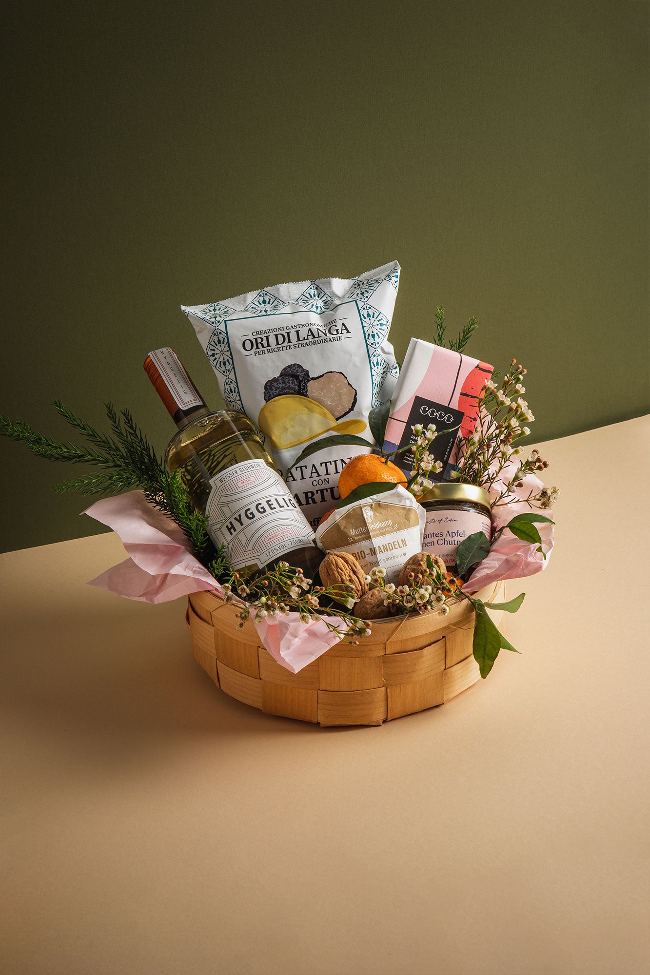 Geschenkkorb von Feasts of Eden mit Weißwein, Trüffelchips, Chutney, Schokolade, Mandarinen und Walnüssen