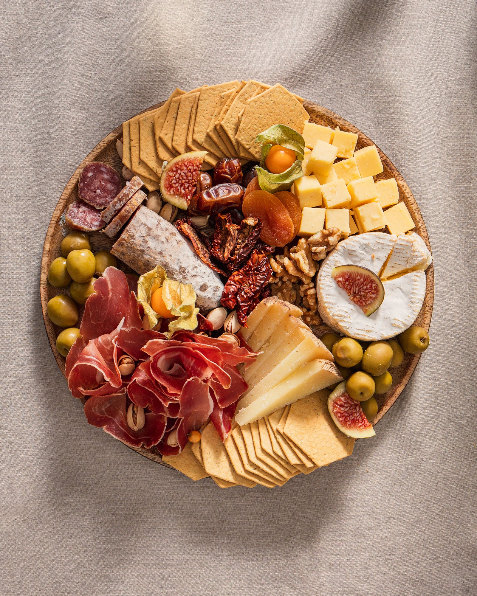 runde Grazing Platte mit Wurst, Käse, getrockneten Früchten, Oliven, Crackern