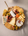 Auswahl an Nüssen, getrockneten Früchten, Käse, Oliven, Feasts of Eden Zwiebelchutney und Crackern arrangiert auf Holzplatte
