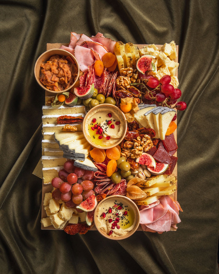 Festliche Grazing Platte von Feasts of Eden mit verschiedenen Käse und Wurstsorten, Hummus, Obst, Oliven und Walnüssen 